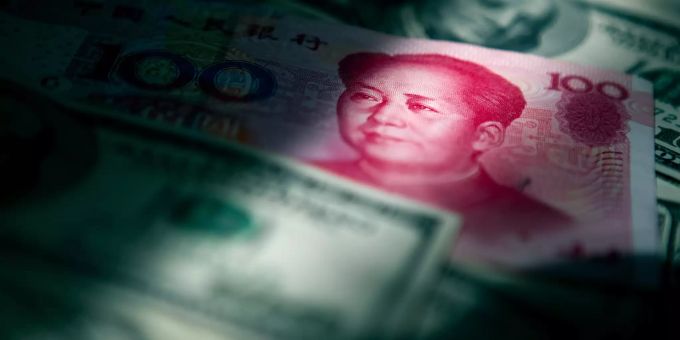 Ein Lichtstrahl fällt auf chinesische und US-amerikanische Banknoten. Verluste an den Aktienmärkten haben im vergangenen Jahr am Vermögen der Reichen und Superreichen in der Welt genagt. Weniger Dollar-Millionäre