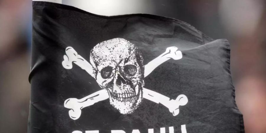 Eine Eckfahne des FC St. Pauli mit dem Totenkopf-Logo weht im Wind. Foto: Malte Christians/dpa