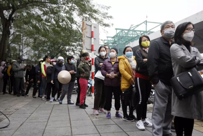 Menschen mit Schutzmasken in Vietnam. Coronavirus Vietnam
