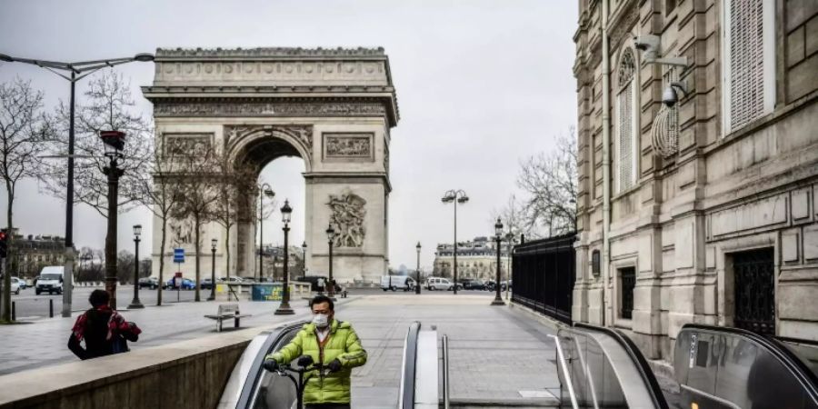 Ein Mann im menschenleeren Paris am Triumphbogen