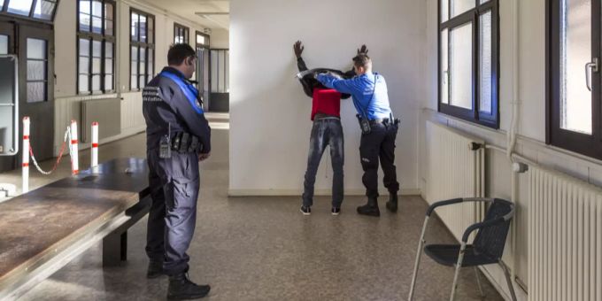 Grenzwächter durchsuchen einen Asylsuchenden, der ohne Papiere bei Chiasso über die Grenze kam. Grenzwacht Asylsuchender Chiasso