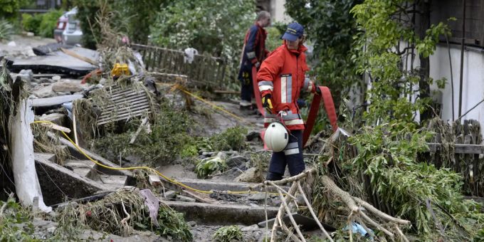 Rettungskräfte räumen Unwetterschäden auf, in Dierikon LU 2015. In Dierikon überflutete der Dorfbach nach heftigen Regenfällen Garagen und riss ganze Strassenabschnitte weg. Dierikon