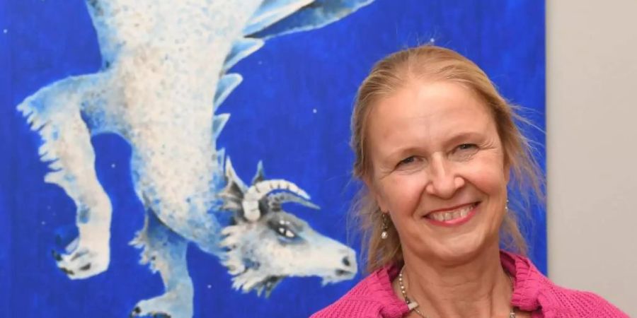 Cornelia Funke vor ihrem Werk «Saum des Himmels» aus dem Jahr 2016. Foto: Uli Deck/dpa