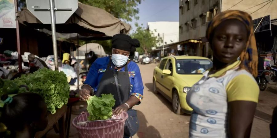 Gemüseverkäuferin mit Mali mit Atemschutzmaske