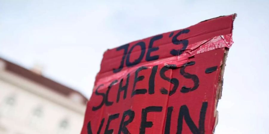 Klare Worte: Ein Demonstrant hält während einer Protestaktion von Fridays for Future vor der Siemens-Zentrale ein Schild mit der Aufschrift «Joe's Scheiss-Verein». Foto: Matthias Balk/dpa