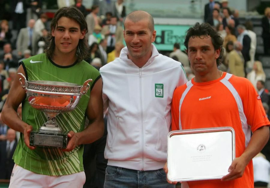 Turniersieger Rafael Nadal (links) und Zweitplatzierter Mariano Puerta (rechts) posieren mit Pokal, Schale und Zinédine Zidane nach den French Open 2005.