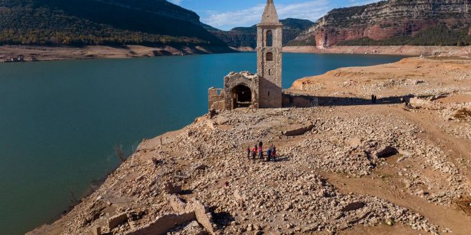 Eine Kirche und die Überreste eines alten Dorfes, die normalerweise vom Wasser bedeckt werden, sind im Inneren des Stausees von Sau in Spanien zu sehen. wasser