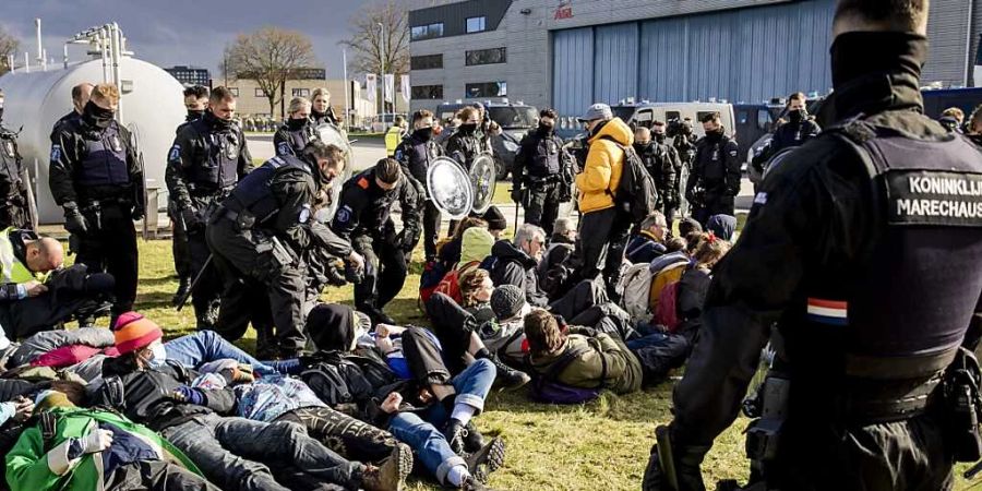 Ein Klimaaktivist von Extinction Rebellion wird während einer Aktion am Flughafen Eindhoven festgenommen. Foto: Sem Van Der Wal/ANP/dpa