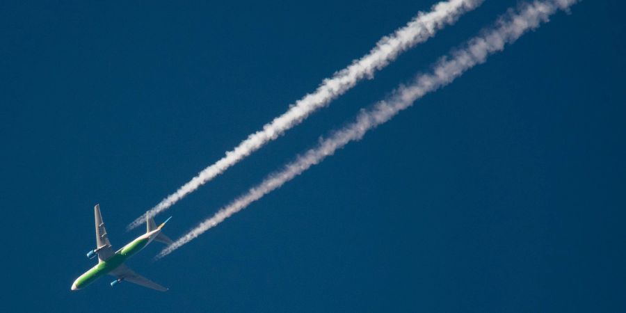 Ein Flugzeug hinterlässt Kondensstreifen am Himmel. Spätestens Mitte des Jahrhunderts soll schliesslich mit grünem Wasserstoff geflogen werden.
