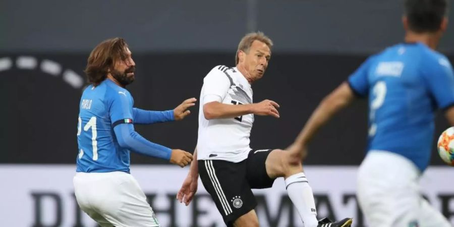 Jürgen Klinsmann (M) trift zum 2:0 für die DFB-All-Star, Italiens Andrea Pirlo (l) kommt zu spät. Foto: Daniel Karmann/dpa