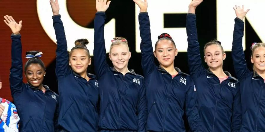 Die US-Turnerinnen um Simone Biles (l) feiern in Stuttgart den WM-Titel. Foto: Tom Weller/dpa