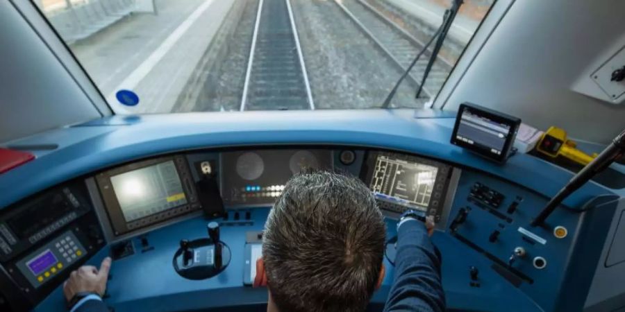 Ein Lokführer im Führerstand eines Diesel-Triebwagens der Deutschen Bahn. Foto: Daniel Karmann/dpa