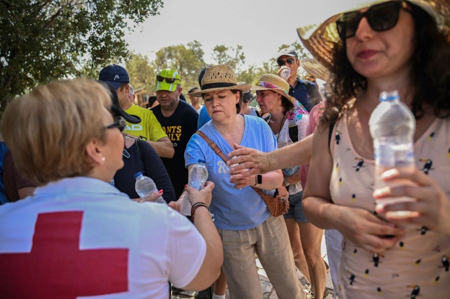 Mitarbeiter des Griechischen Roten Kreuzes verteilen vor der Akropolis Wasserflaschen an  Besucher. Angelos Tzortzinis/dpa