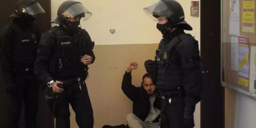 Rapper Pablo Hasél hebt bei seiner Festnahme in der Universität von Lleida die Faust. Foto: Joan Mateu/AP/dpa