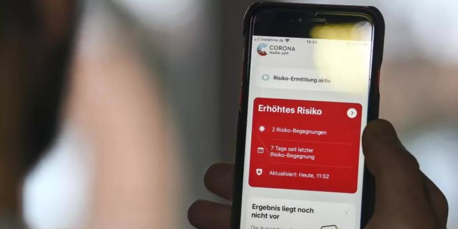 Auf einem Handy zeigt die «Corona Warn-App» ein erhöhtes Risiko an, wenn ein längerer Kontakt mit einer infizierten Person registriert wurde. Foto: Kira Hofmann/dpa-Zentralbild/dpa