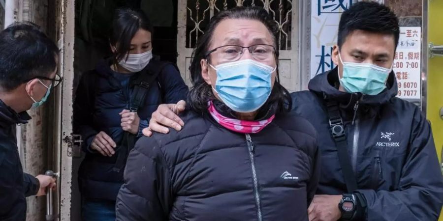 Daniel Wong Kwok-tung (l), Bezirksrat und Anwalt aus dem Stadtteil Kowloon in Hongkong, wird von Polizisten aus seinem Büro eskortiert. Foto: Isaac Wong/SOPA Images via ZUMA Wire/dpa