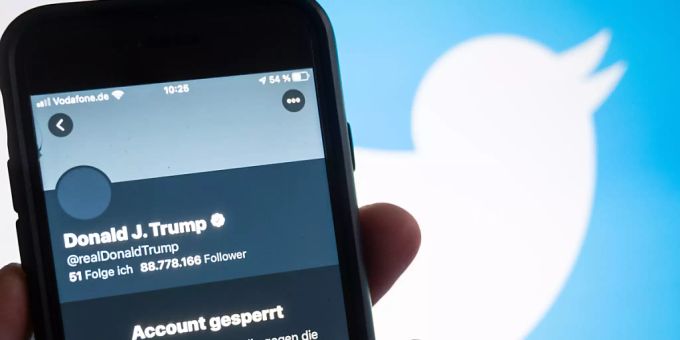 Ein Smartphone, auf dessen Bildschirm der gesperrte Twitteraccount @realdonaldtrump von Donald Trump zu sehen ist. Trump Tweet