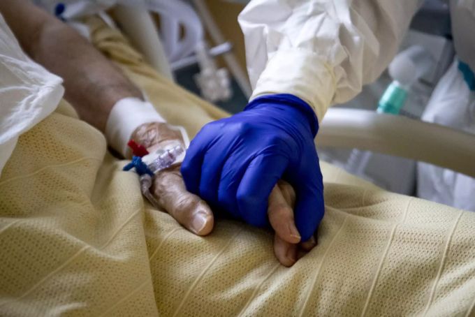 Ein italienischer Gesundheitsarbeiter hält die Hand einer Patientin, die am Coronavirus erkrankt ist. Coronavirus