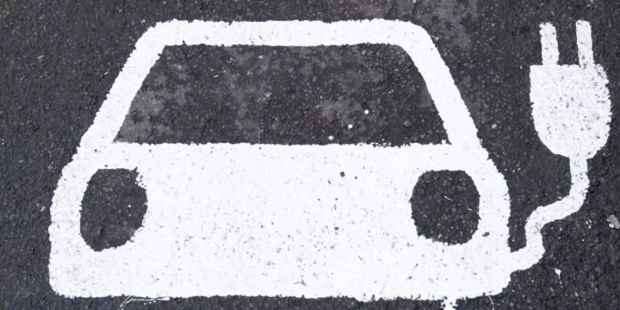 Ein Symbol für ein Elektroauto markiert einen Parkplatz neben einer E-Ladesäule. Foto: Julian Stratenschulte/dpa