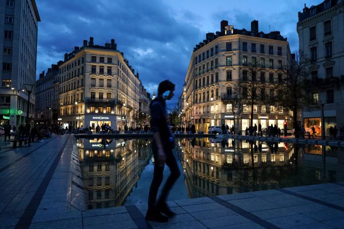Ein Mann, dem ein Mund-Nasen-Schutz am Ohr hängt, geht durch die Innenstadt von Lyon. Mit Ausgangsbeschränkungen im ganzen Land verschärft das Frankreich seinen Kampf gegen die zweite Welle der Corona-Pandemie. Coronavirus - Frankreich