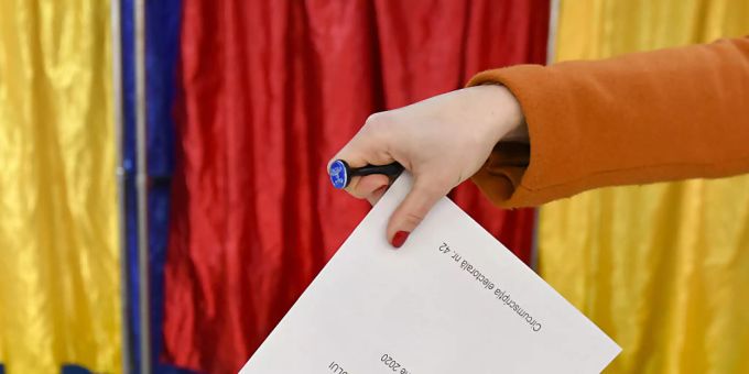 Eine Frau gibt bei Wahlen in Rumänien ihren Stimmzettel ab. rumänien wahlen