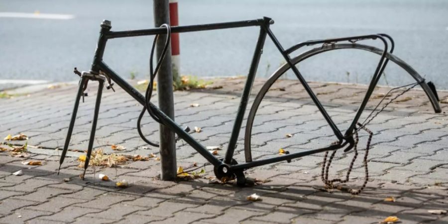 Ausgeweidetes Fahrrad an Verkehrsschild