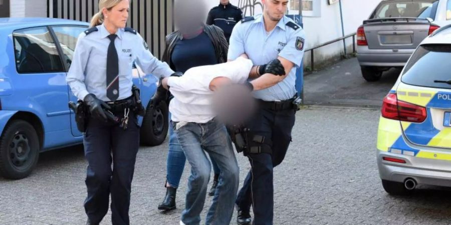 Ein mutmasslich Verdächtiger wird von Polizeibeamten abgeführt, im Hintergrund eine Zivilfahnderin der Polizei. Foto: Stephan Witte/KDF-TV & Picture 2019