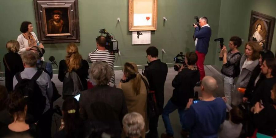 Banksys Bild «Love is in the Bin» (M) zwischen Alten Meistern in der Staatsgalerie Stuttgart. Foto: Sebastian Gollnow