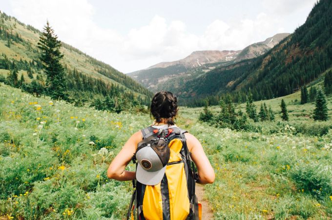 Fragen Sie bei der Person nach, ob sie sich etwas für ihre Outdoor-Ausrüstung wünscht. Eine Wanderin im Gebirge