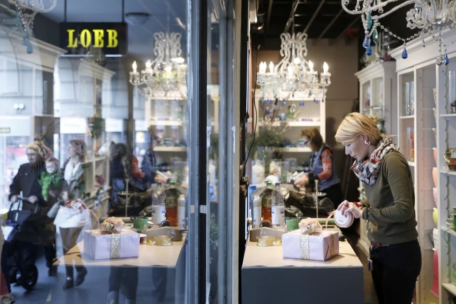 Dekorationsgestalterinnen packen in einem Schaufenster des Kaufhauses Loeb in Bern Geschenke ein.