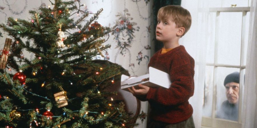 Während der nichtsahnende Kevin (Macaulay Culkin, l.) den Weihnachtsbaum schmückt, lauert Harry (Joe Pesci) auf eine Gelegenheit, das Haus auszurauben.