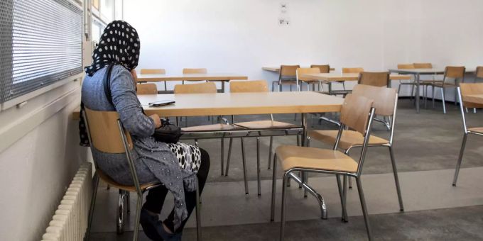 Eine Asylbewerberin sitzt an einem Tisch. (Symbolbild) Asylzentrum
