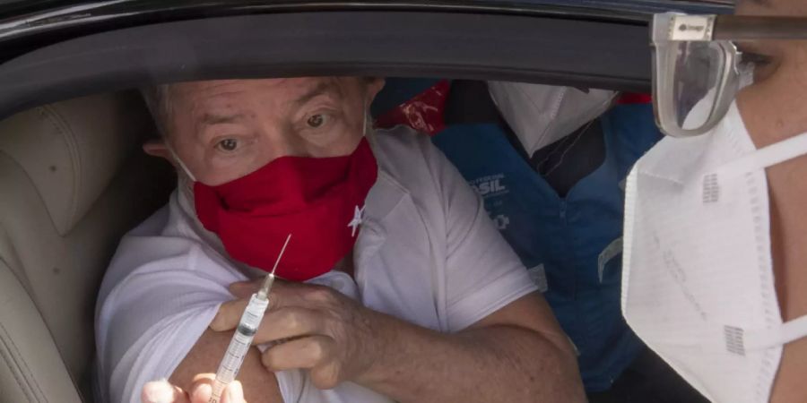 Luiz Inacio Lula da Silva, ehemaliger Präsident von Brasilien, krempelt sich den Ärmel hoch, um an einem Impf-Drive-Thru mit dem Coronaimpfstoff des chinesischen Unternehmens Sinovac geimpft zu werden. Foto: Andre Penner/AP/dpa