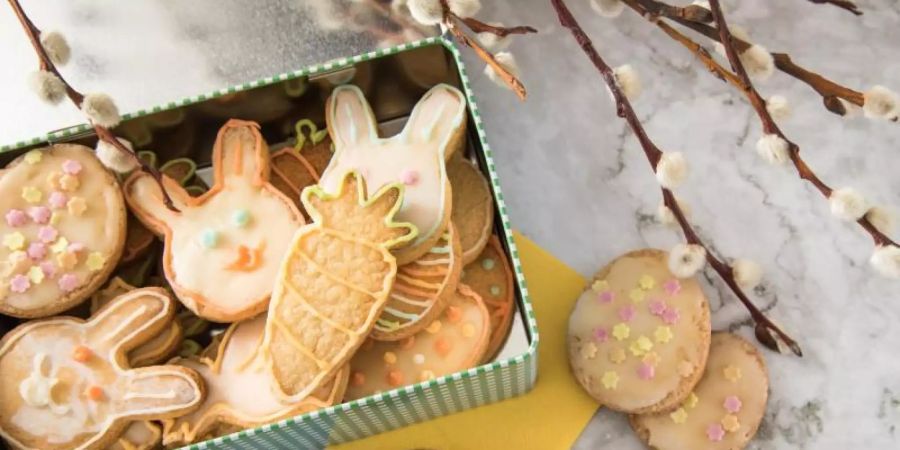 Putzige Zitronenplätzchen tummeln sich in einer Keksdose auf dem Ostertisch. Was sonst eigentlich Weihnachten versüsst, funktioniert auch fürs Osterfest. Also ran an das Backen mit Kindern. Foto: Christin Klose/dpa-tmn