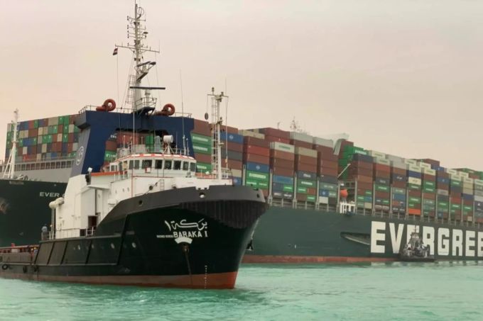 Ein Schlepper fährt an dem Containerschiff Ever Given vorbei, nachdem es im südlichen Ende des Suezkanals auf Grund gelaufen ist. Containerschiff Suezkanal