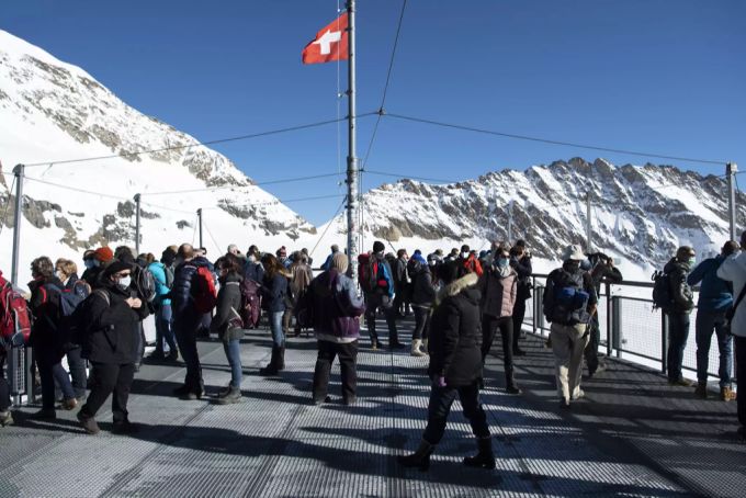Etliche Touristen stehen auf der Aussischtsplattform Sphinx auf 3454 Meter über Meer auf dem Jungfraujoch. Jungfraujoch