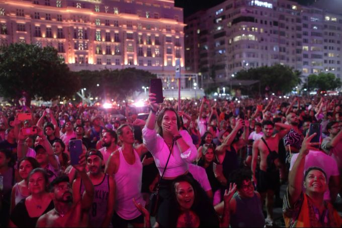 Eine grosse Masse von Menschen tanzt zu Madonna auf der Copacabana. madonna copacabana