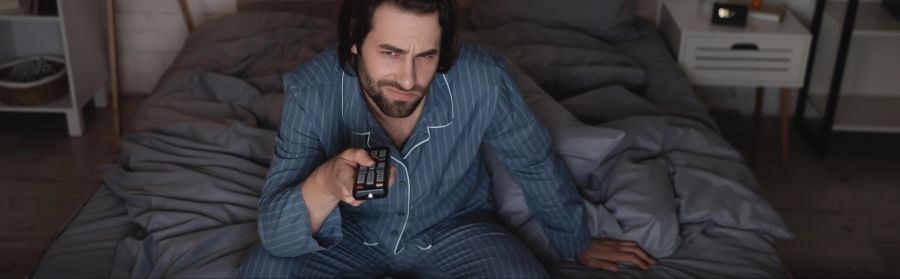 Mann Fernbedienung Nacht Bett