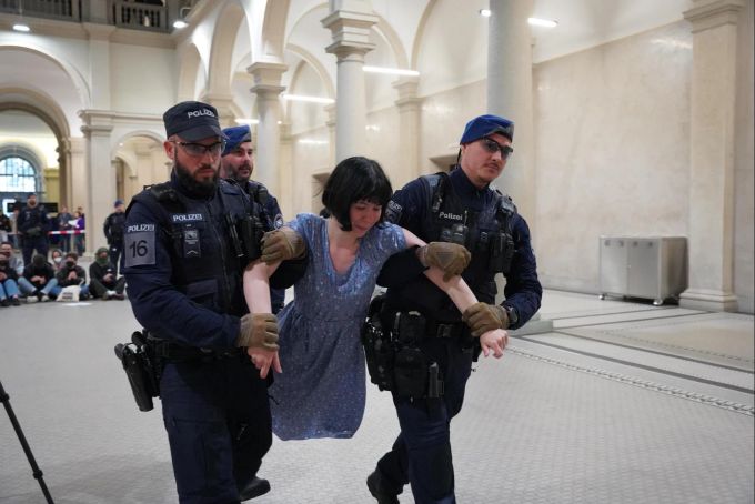 Drei Polizisten tragen eine Demonstrantin aus dem Hauptgebäude der ETH Zürich. eth zürich