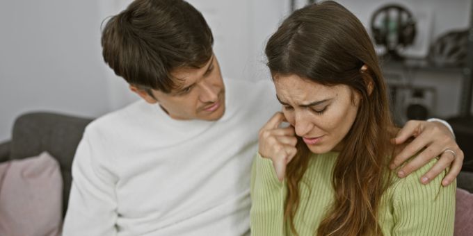 Was war, bevor wir uns trafen? Die quälende Frage bei retroaktiver Eifersucht. Mann tröstet traurige Frau