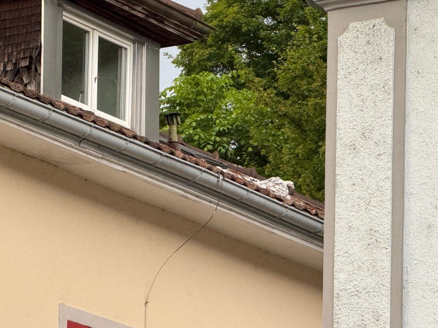 Auf einem Hausdach sind zudem Kleidungsstücke zu sehen.