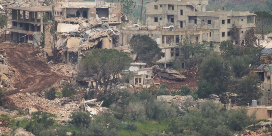Israelische Soldaten fahren einen Panzer in ein Dorf im Südlibanon, gesehen vom Norden Israels aus. Foto: Ariel Schalit/AP/dpa