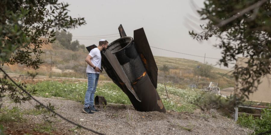 ARCHIV - Ein israelischer Mann betrachtet in der jüdischen Siedlung im nördlichen Jordantal das Heckteil einer vom Iran abgeschossenen ballistischen Rakete. Foto: Oren Ziv/dpa