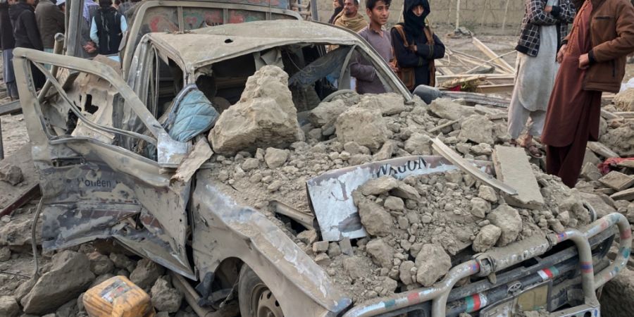 ARCHIV - Anwohner stehen neben einem beschädigten Auto am Ort eines grenzüberschreitenden Angriffs der pakistanischen Armee in der Provinz Nangarhar. Foto: Hedayat Shah/AP/dpa