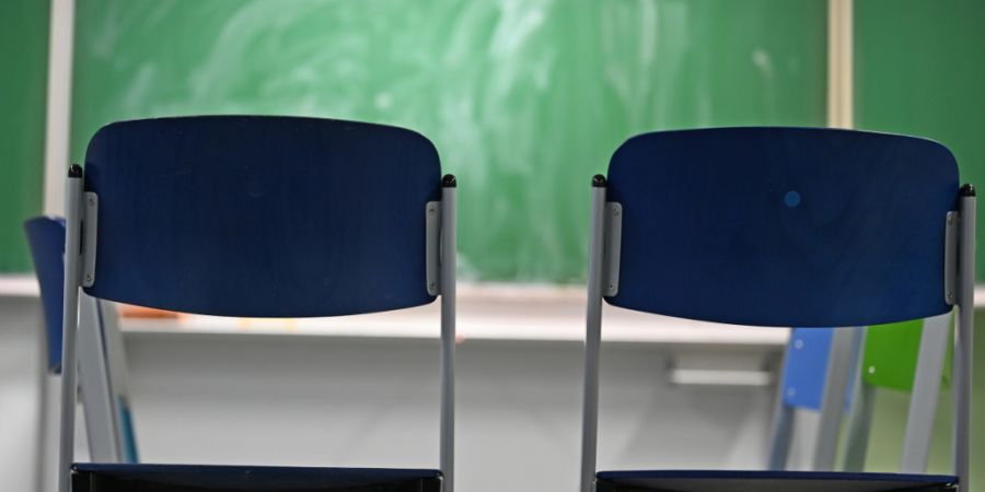 ARCHIV - Zwei leere Stühle stehen in einem Klassenraum vor einer Tafel. Foto: Michael Brandt/dpa