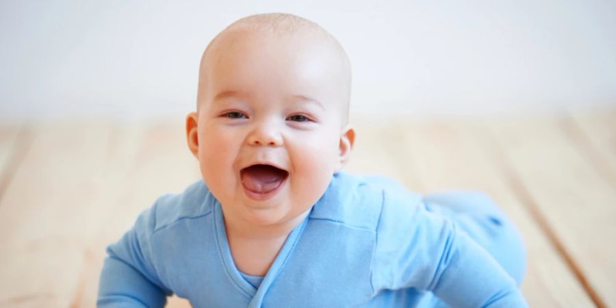 Baby Lachen auf dem Bauch blauer Strampler