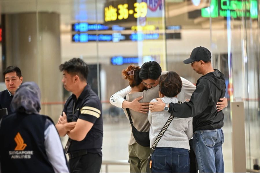 Ein Passagier, der die Turbulenzen miterlebte, wird in Singapur von seiner Familie empfangen.