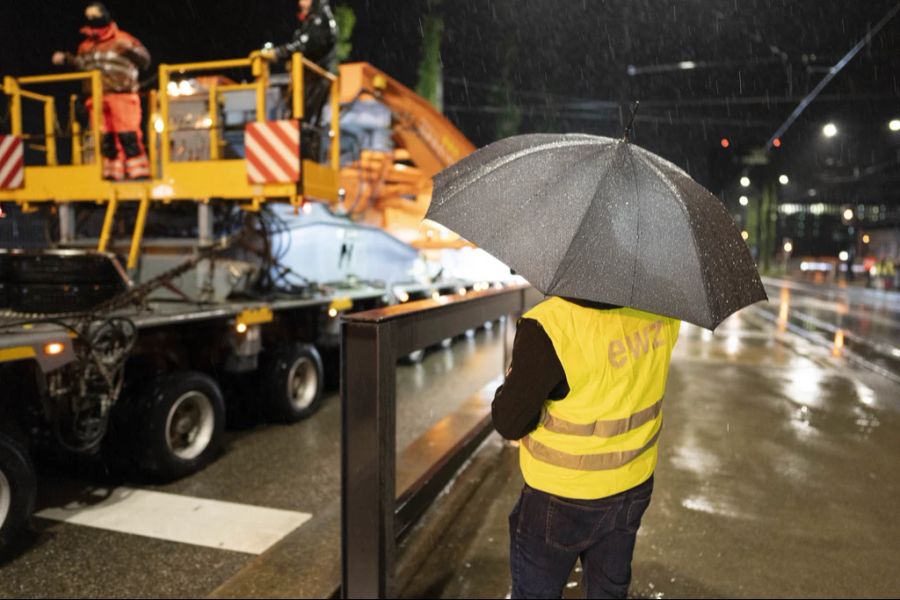 Ein Mitarbeiter des EWZ beobachtet den Trafo-Transport in Zürich.