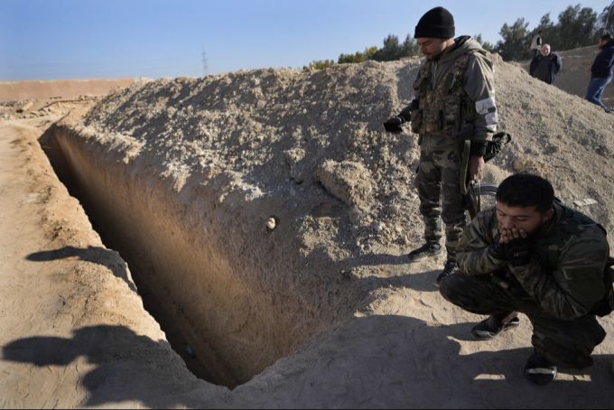 Syrische Rebellen inspizieren ein Massengrab in der Nähe von Damaskus, Syrien. Massengrab Syrien Leichen Assad