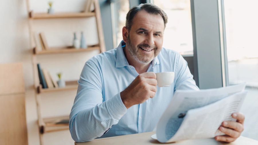 älterer mann liest in café